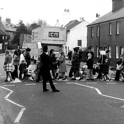 Demonstration for a bypass for Stanstead Abbotts. We would walk back and forth across the crossing forcing traffic to build up. The police used to clear the road when the hold up became excessive. Traffic through the village was non stop as it was the main A414 to Harlow. Photo April 1975. The bypass finally opened in 1987.